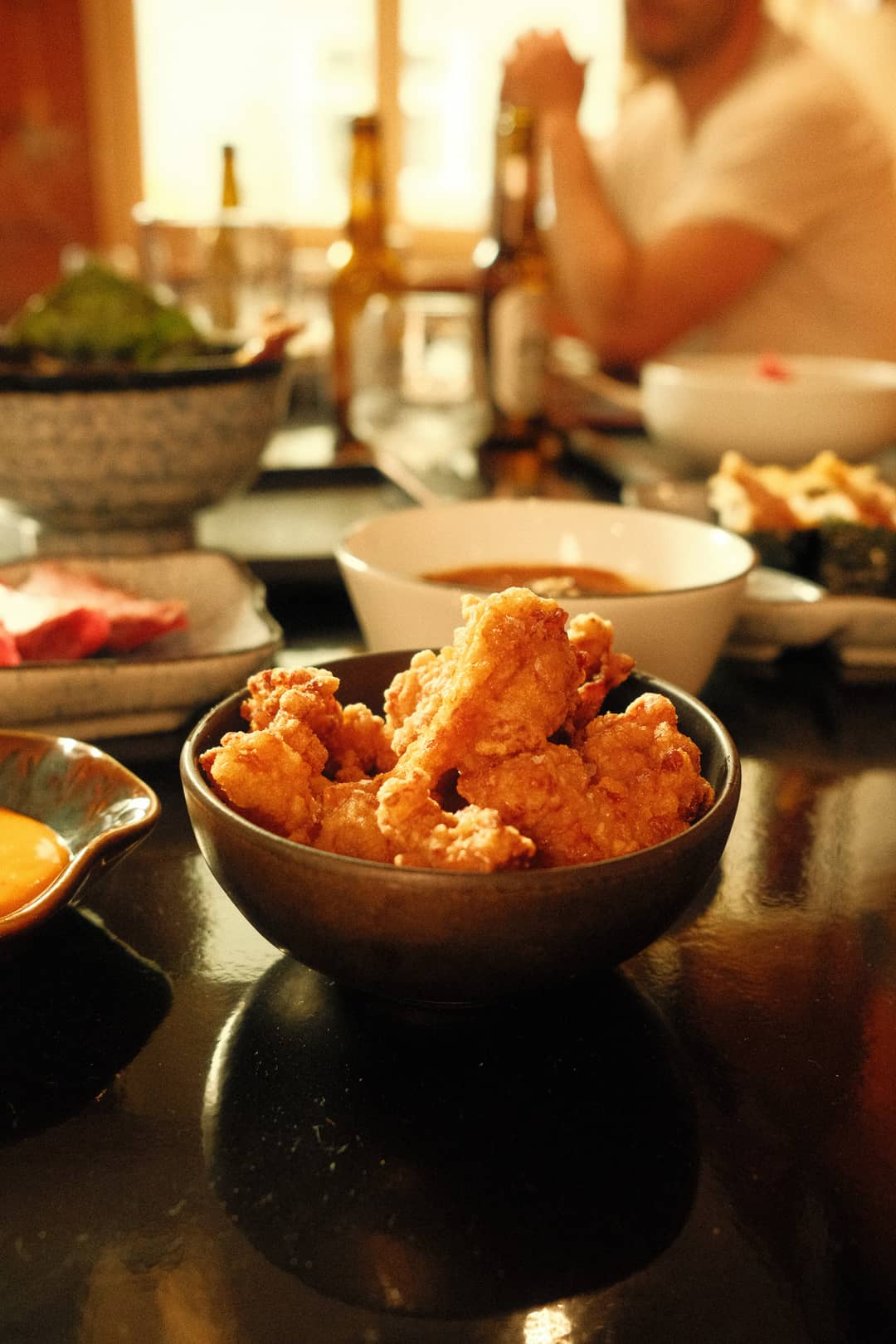 Crispy fried chicken in a dark bowl at SHOKUDO Izakaya, a Japanese restaurant in Zurich.