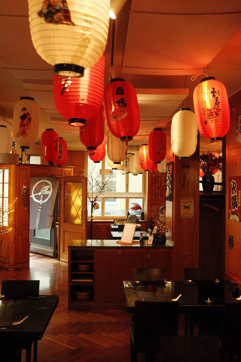 SHOKUDO Izakaya interior with red paper lanterns, wooden décor, and traditional Japanese restaurant ambiance in Zurich.